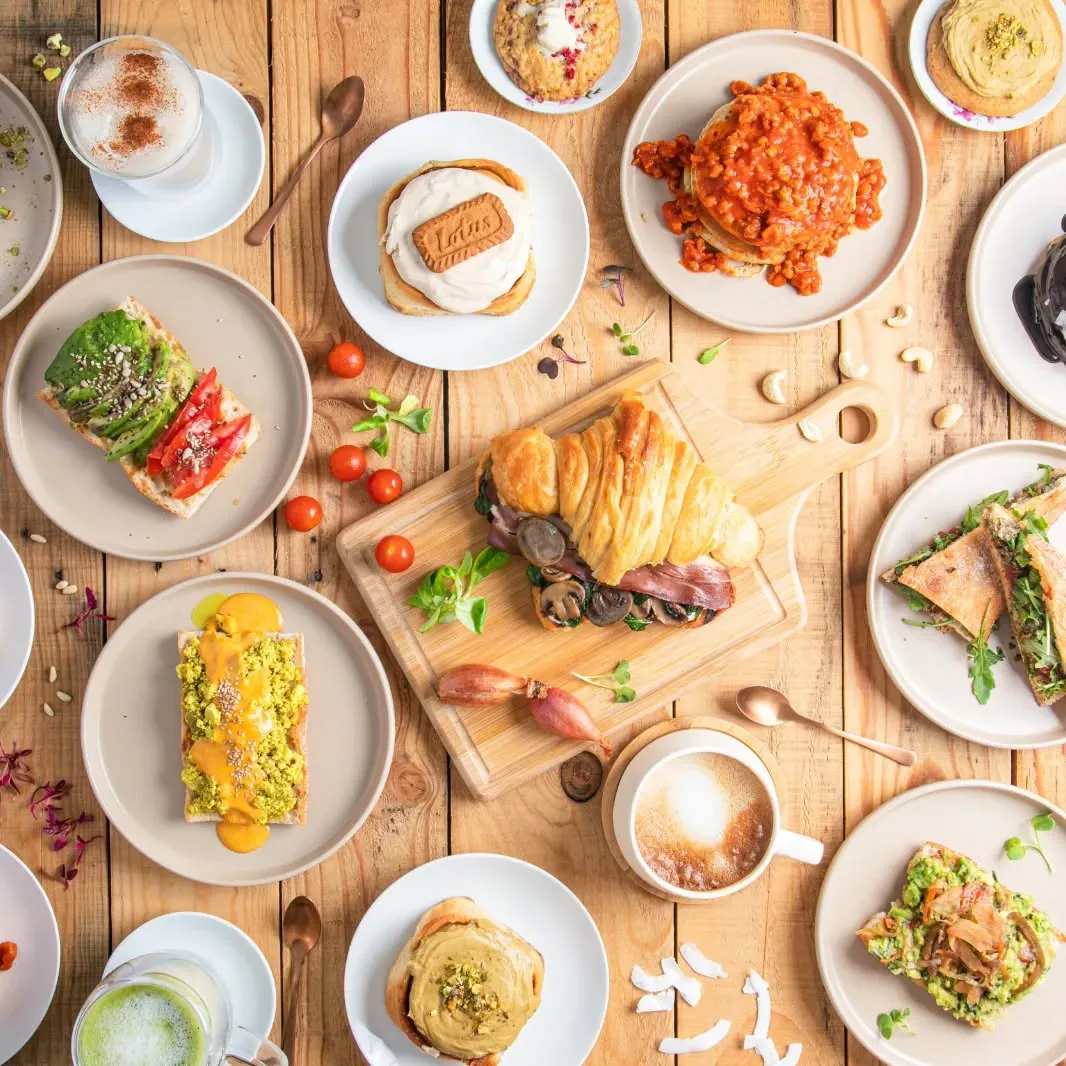 Mesa de madera llena de platos de brunch